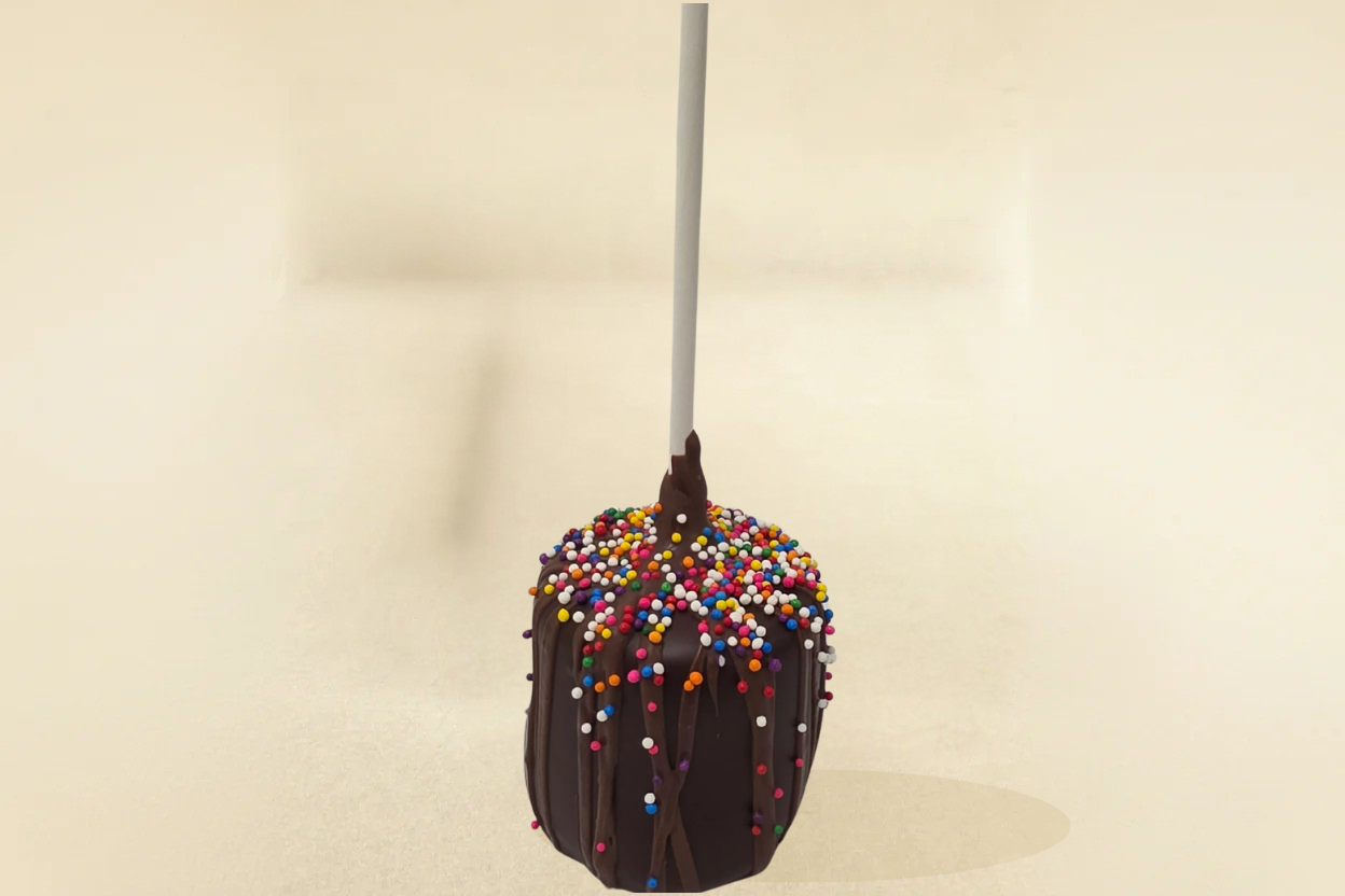 Dark chocolate marshmallow pop with milk drizzle and sprinkles