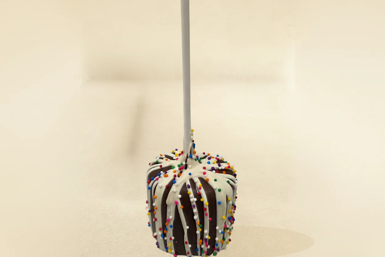 Milk chocolate marshmallow pop with white drizzle and sprinkles