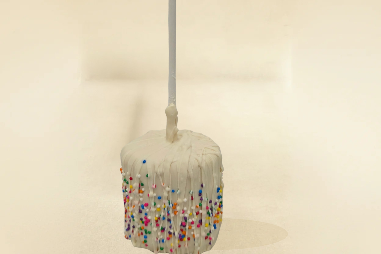 white chocolate marshmallow pop with white drizzle and sprinkles